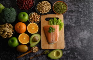 High-protein foods like lentils, beans, broccoli, and avocado arranged on a table.