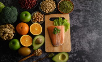 High-protein foods like lentils, beans, broccoli, and avocado arranged on a table.