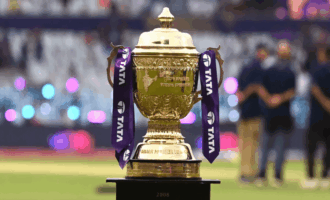 IPL trophy with colorful fan decorations and blurred stadium background