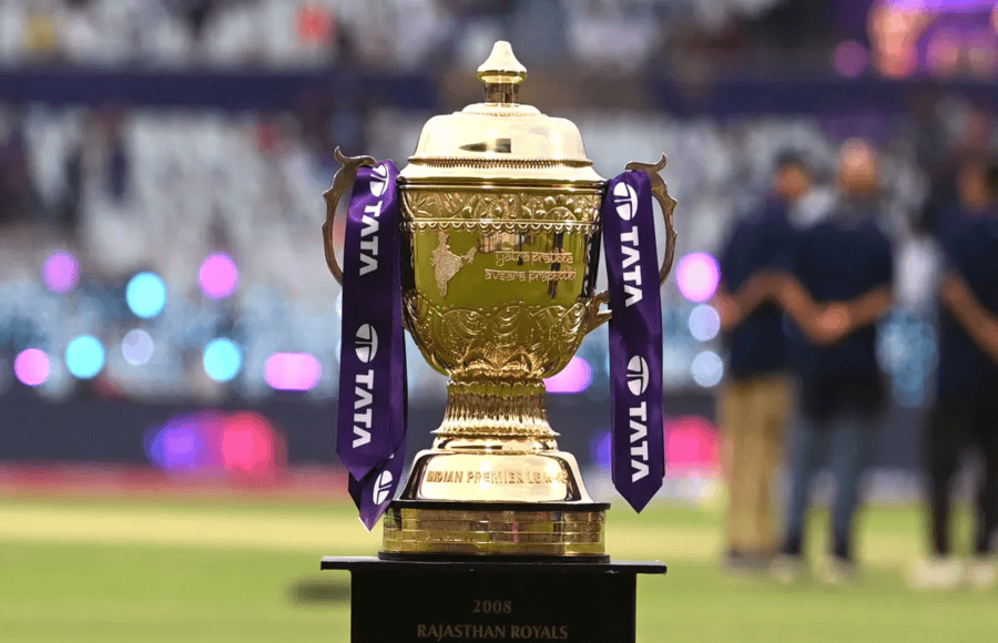 IPL trophy with colorful fan decorations and blurred stadium background
