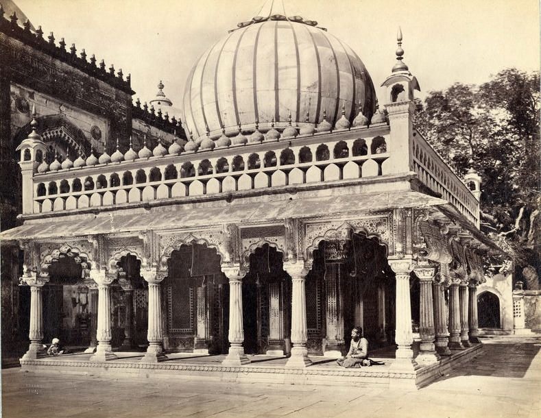 Blurred view of Nizamuddin Auliya Dargah with steps and stone architecture.