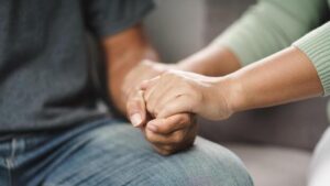 Hands of two people holding each other, showing emotional support and care