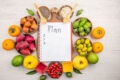 Healthy diet plan with fruits, nuts, and meal planning notebook