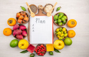 Healthy diet plan with fruits, nuts, and meal planning notebook