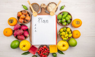 Healthy diet plan with fruits, nuts, and meal planning notebook