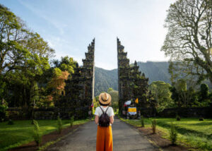 Traveler standing at Bali temple gate surrounded by nature
