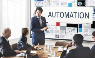 Professional presenting automation strategy to team in meeting room with charts and data visuals