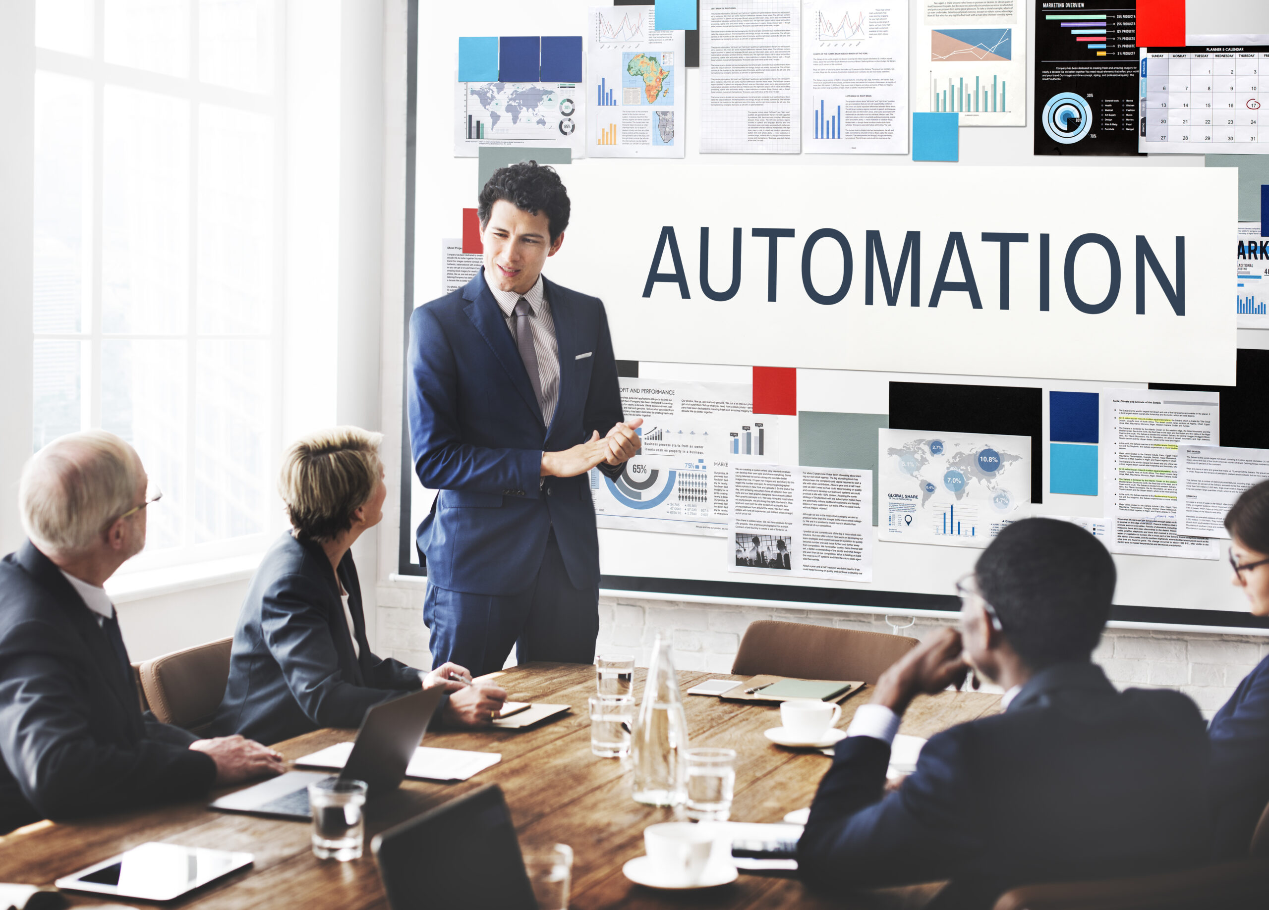 Professional presenting automation strategy to team in meeting room with charts and data visuals