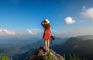 A traveler standing on mountain peak, enjoying scenic view
