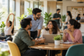 Employees discussing at work in a collaborative office environment, highlighting workplace wellbeing and employee engagement.